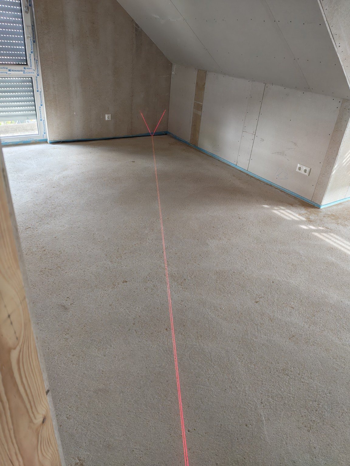 Innenausbau eines Hauses mit sichtbarer Laserlinie auf dem Estrich